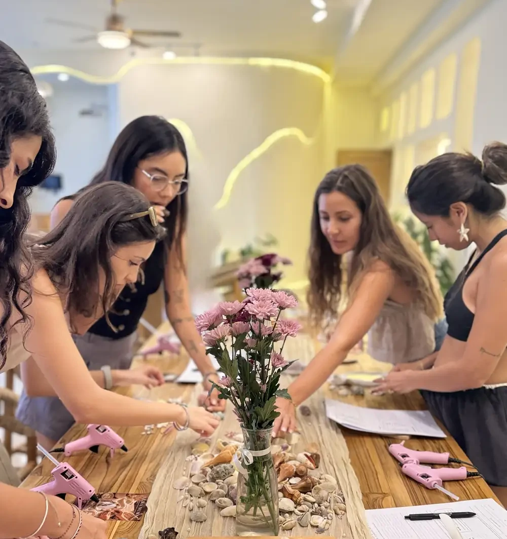 Guests making shell-decorated pieces together at a long table in the Luma Numa studio in Canggu, Bali